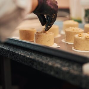 Talented confectioner adding finishing touches to delicious desserts